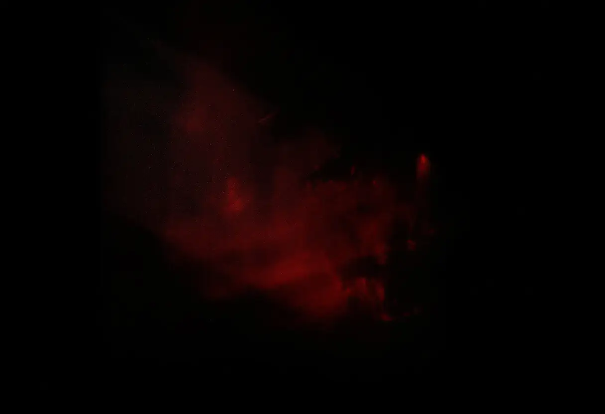 Deep red light diffusing through frosted glass in a dark room